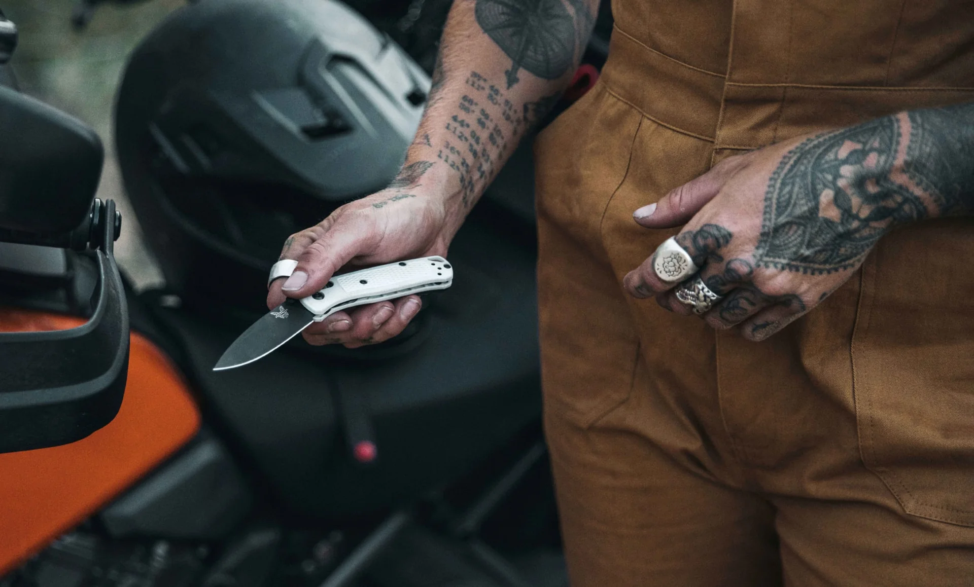 White Benchmade Mini Bugout held beside an orange vehicle