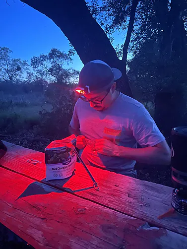 Camper using the red mode of the Black Diamond Distance LT 1100