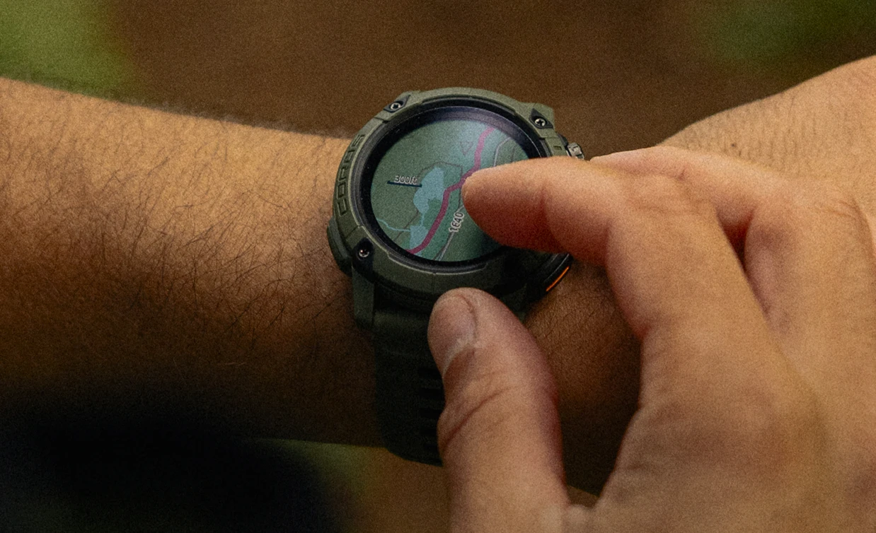 Hand operating the topographic map on a COROS Nomad
