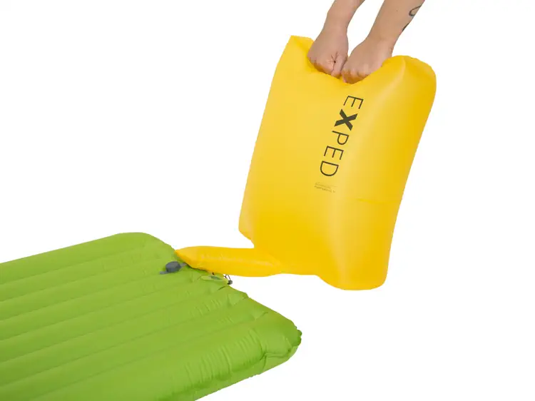Yellow Exped Schnozzel pump bag connected to a green sleeping mat