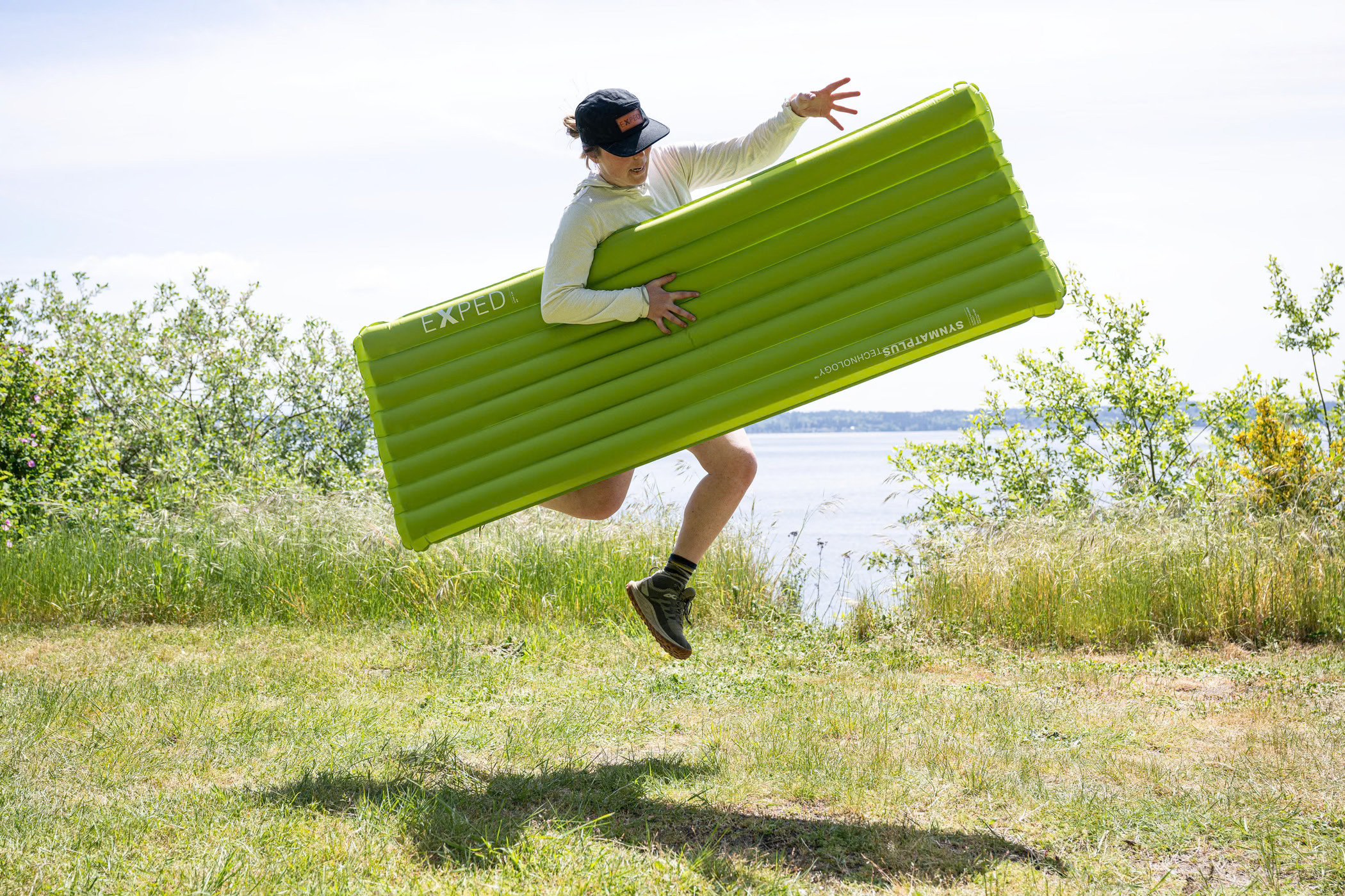 A person carrying an inflated wide Exped sleeping mat outside