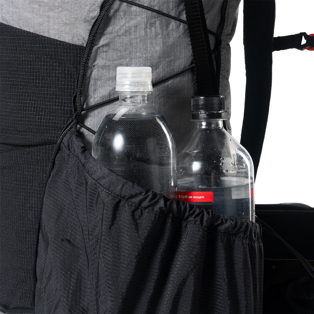Two water bottles held in the side pocket of a Hyperlite Mountain Gear Unbound 40