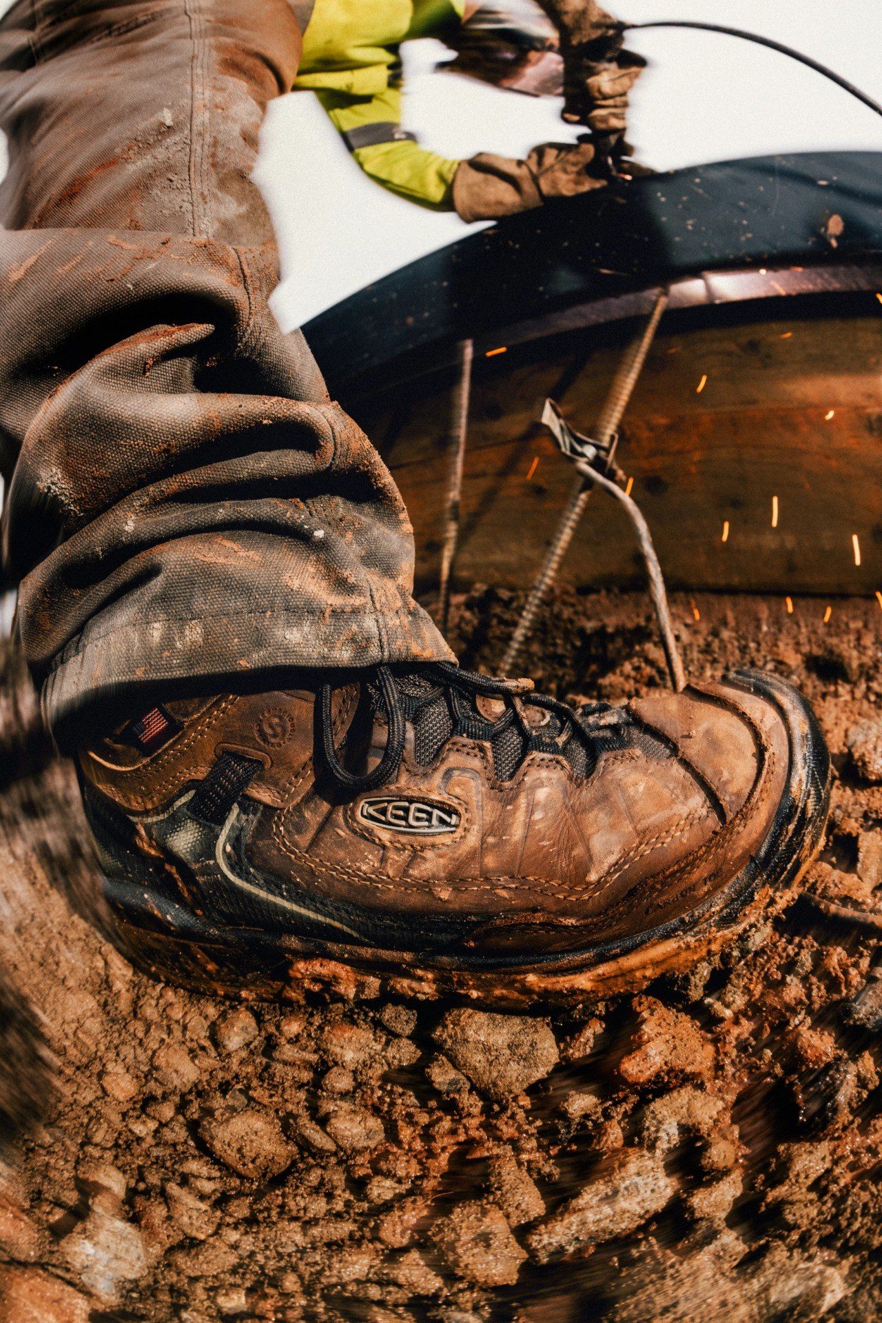 Mud-covered KEEN Targhee IV Work boot on a worksite