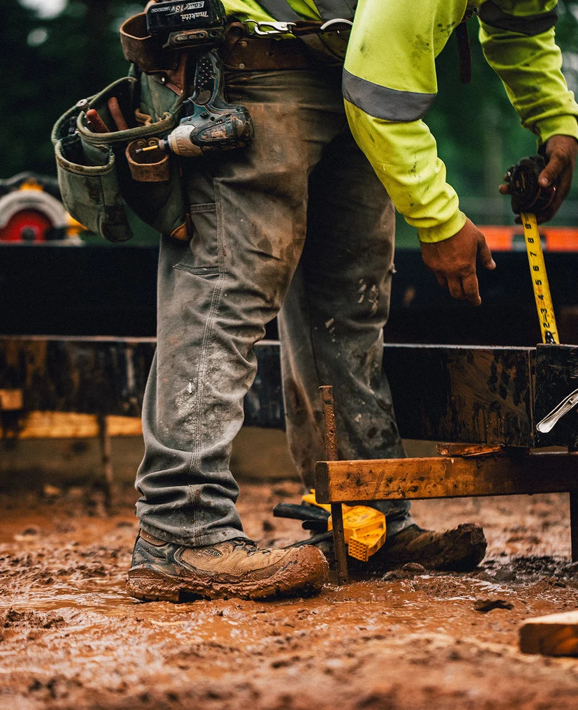 Worker wearing KEEN Targhee IV Work boots on a wet, muddy worksite