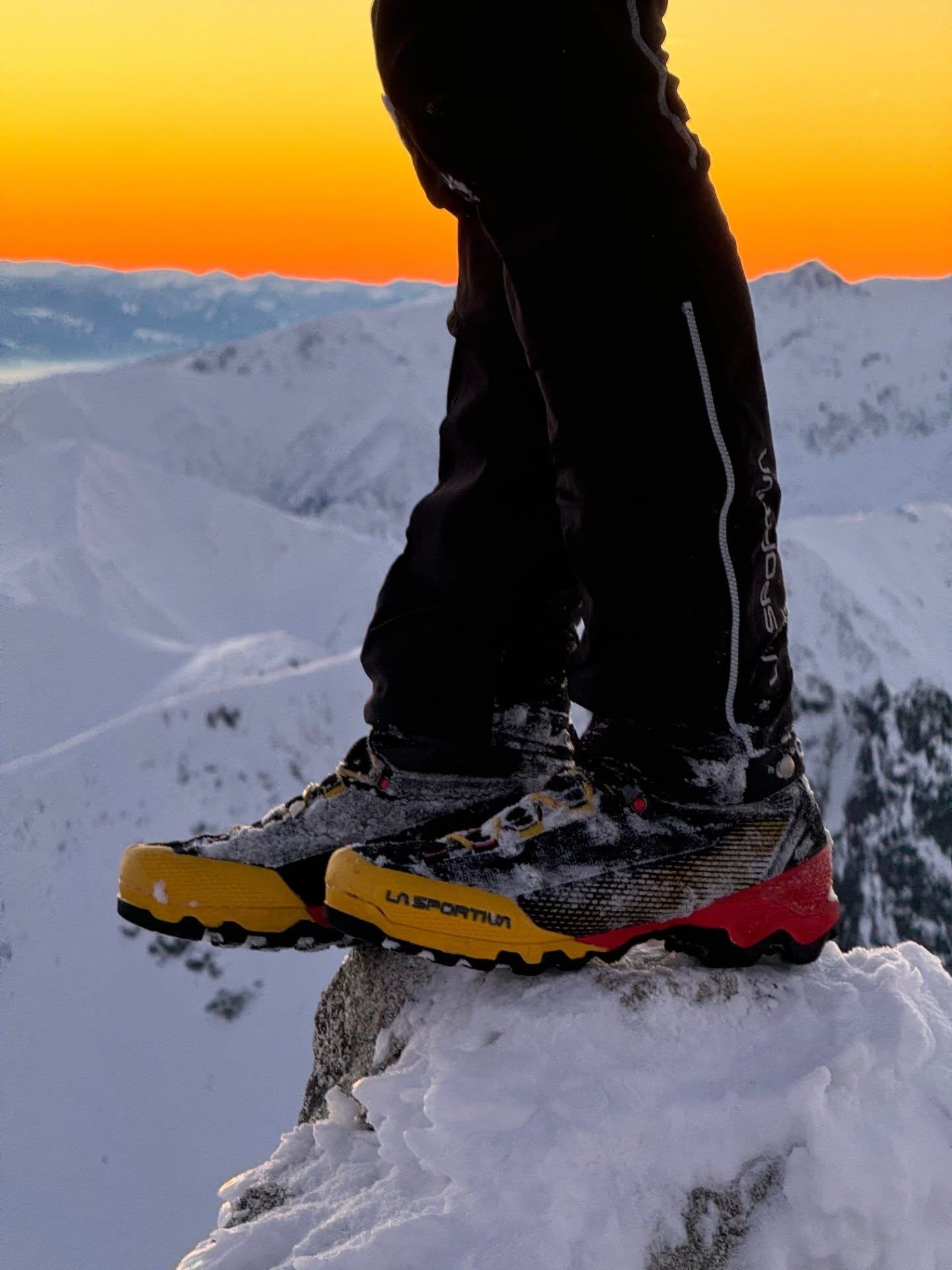 Boots on a snowy mountain at sunset