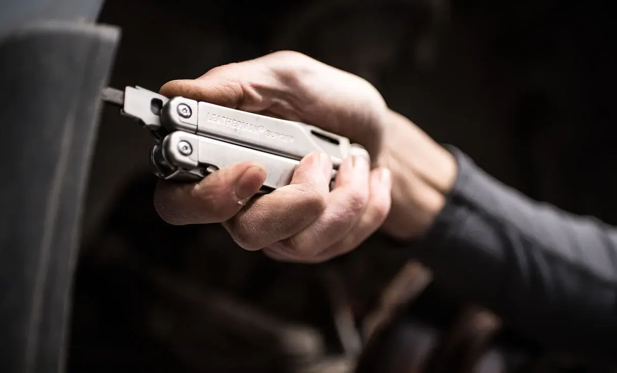 Leatherman Surge using its bit driver on workshop equipment