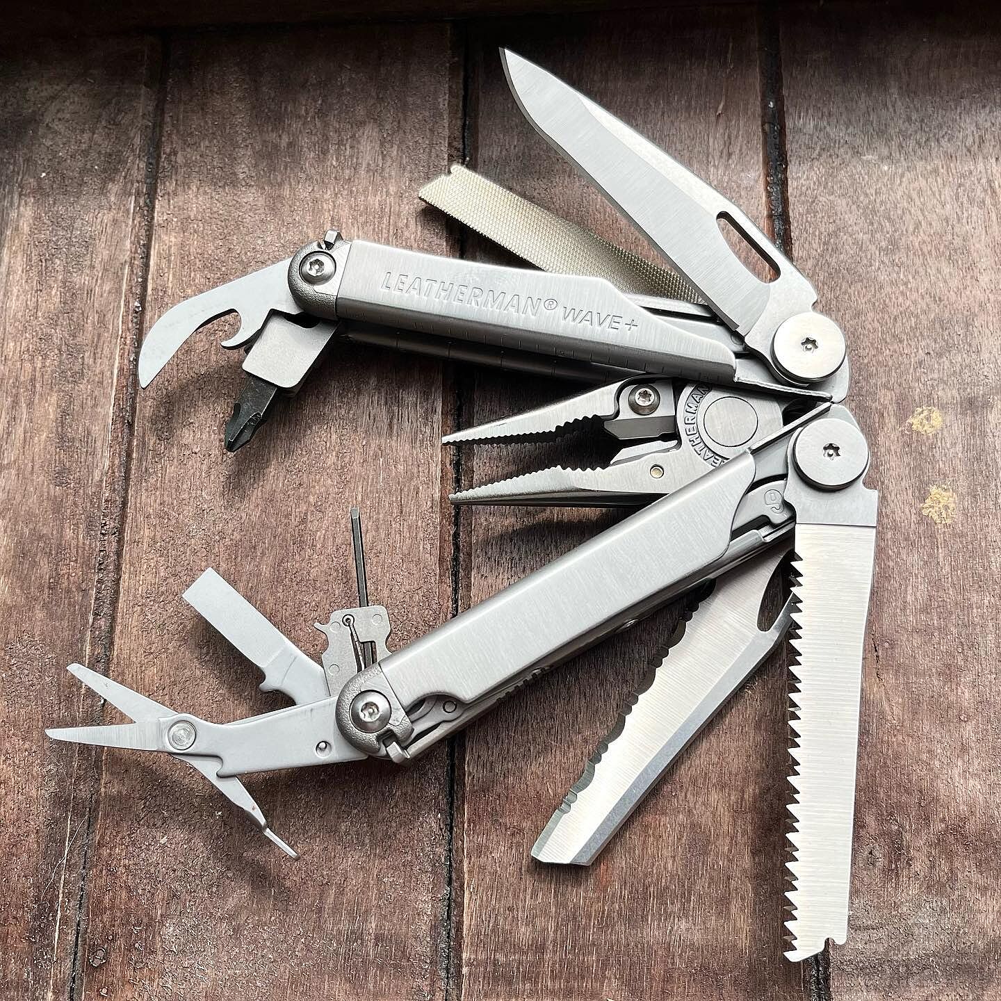 Open Leatherman Wave+ showing plain blade, serrated blade, saw, scissors and other tools