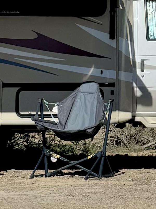 Suspended camp chair set up beside a recreational vehicle