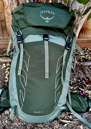 Green Osprey Talon 33 standing beside a tree outdoors