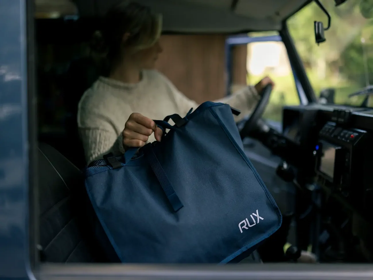 A RUX Bag 25L being lifted into a vehicle