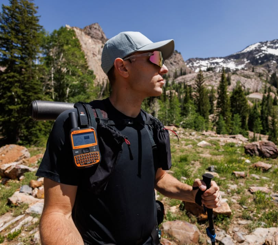 Hiker carrying SPOT X high on a backpack in open country