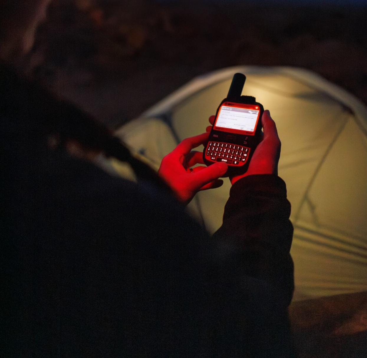 SPOT X screen and keyboard lit inside a tent at night