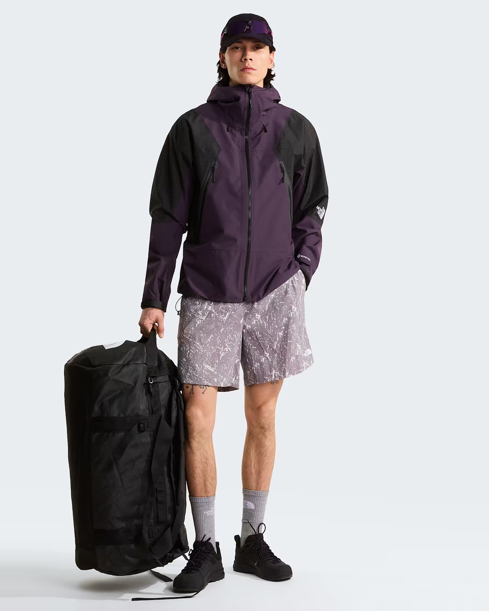 Person standing beside the 95 litre Base Camp Duffel for scale